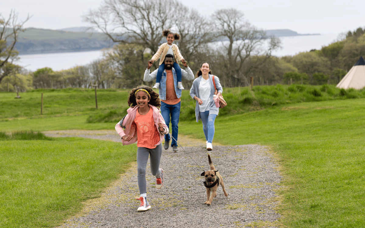 family with children walking a puppy
